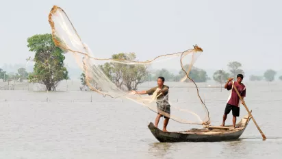 Fishermen throwing a net from their boat 