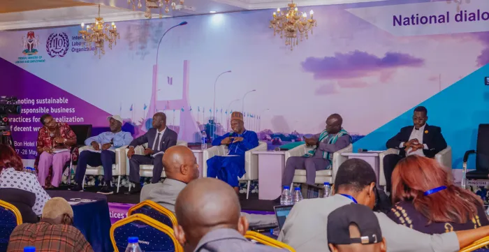 Group of panelists on stage with participants listening